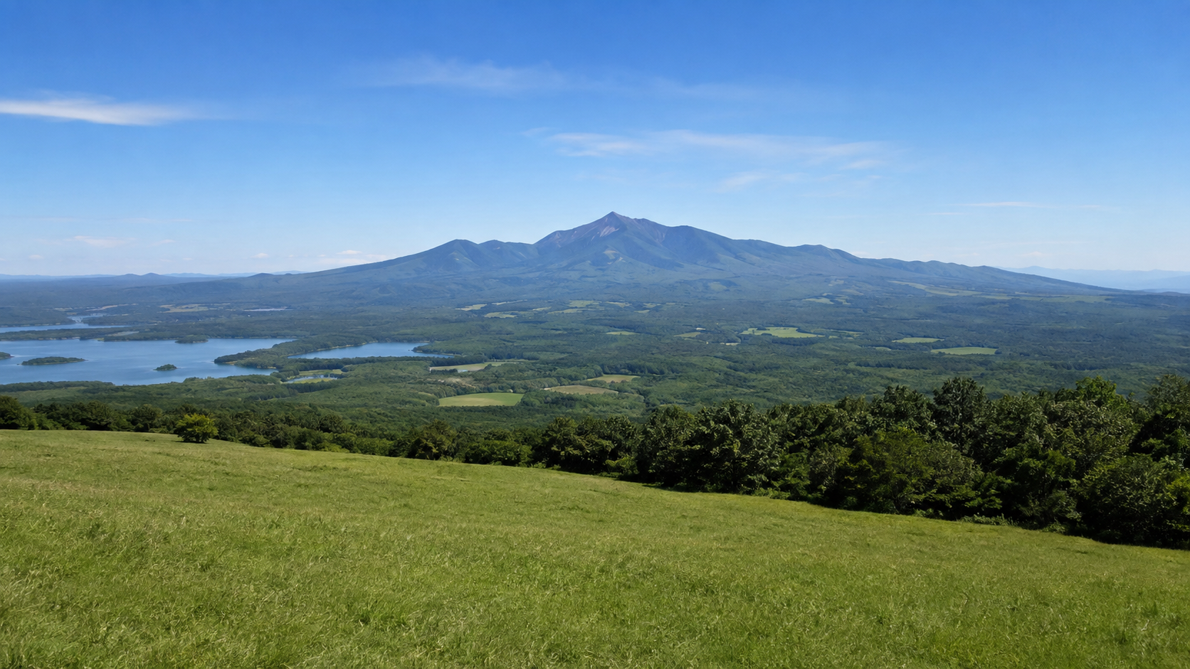 草原から望む大沼国定公園の湖群と雄大な北海道駒ヶ岳の絶景