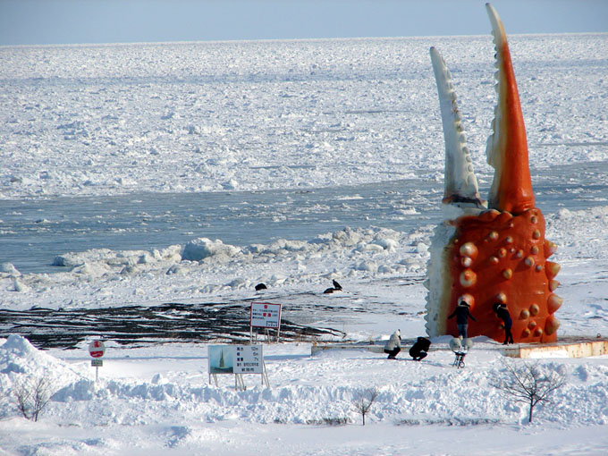 北海道冬旅行のベストシーズンに見られる紋別の流氷と巨大なカニの爪のオブジェ